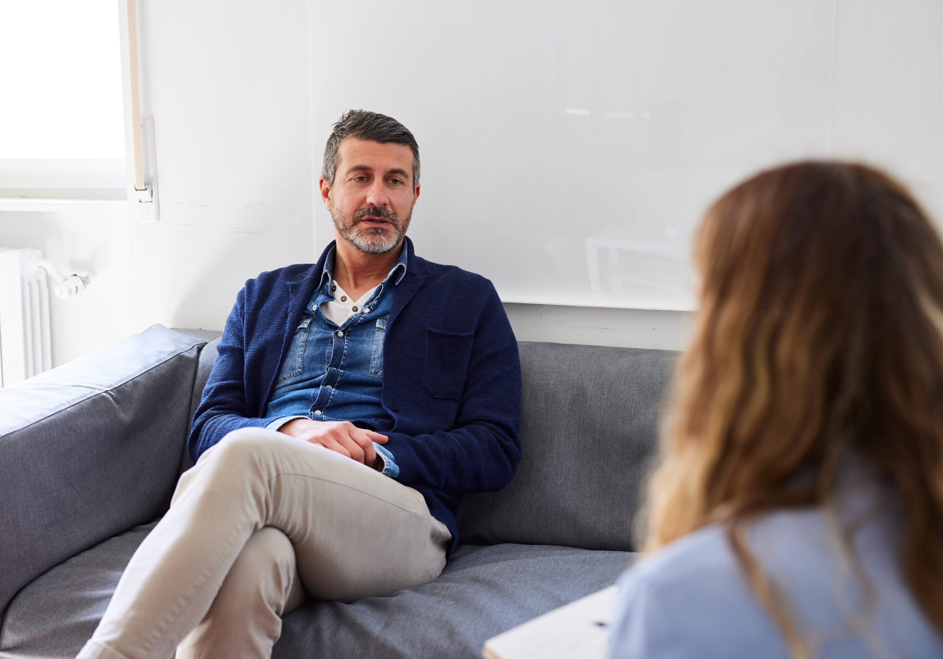 A man sitting on top of a couch next to a woman.