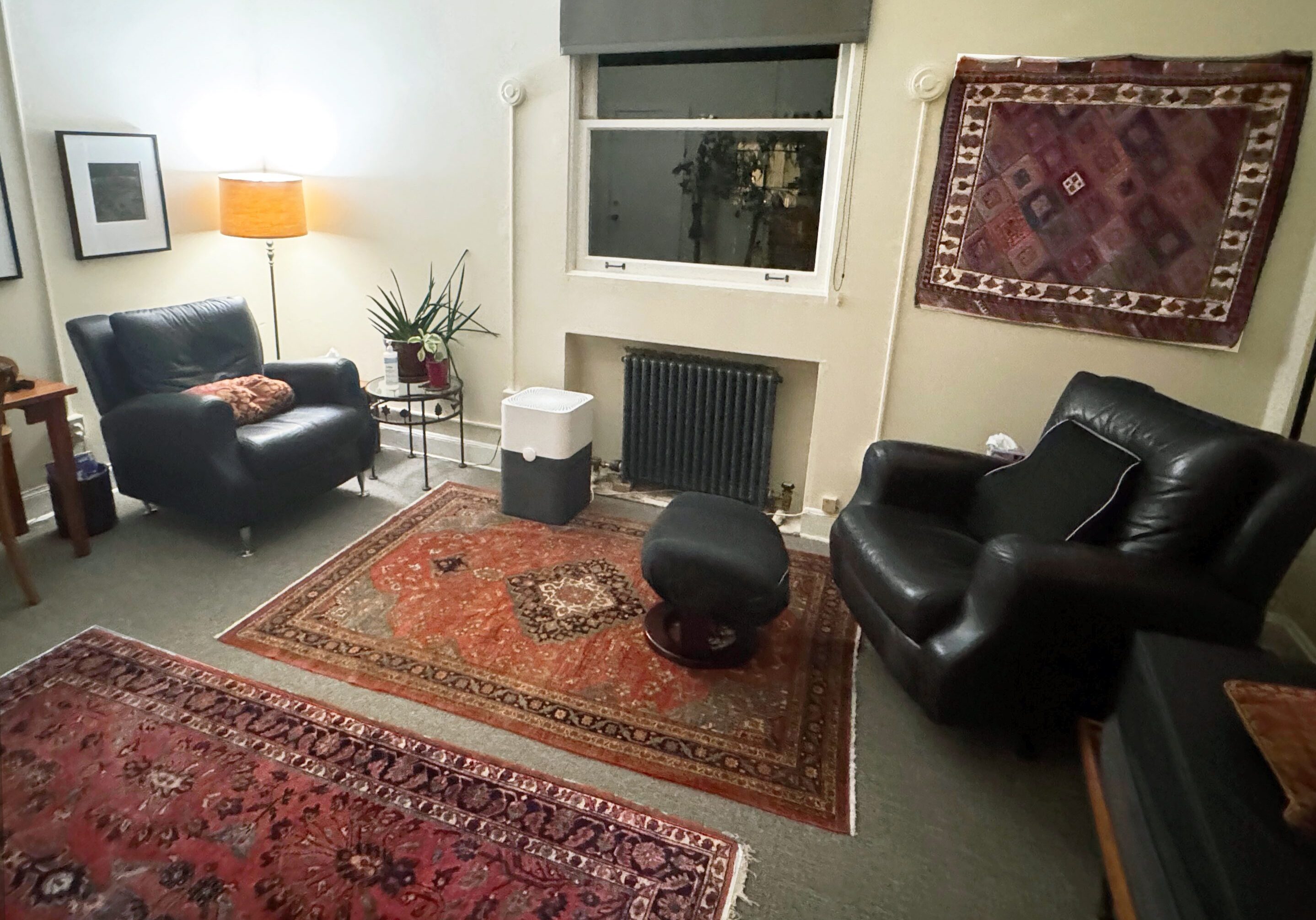 Office Interior A living room with two black chairs and a fireplace.